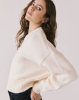 Side view of woman wearing Chaser’s Warm White Luck Zip Up Cardigan Sweater on a white background