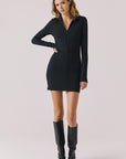 Full body view of woman wearing Chaser’s Lara True Black Mini Dress with long sleeves and black boots on a white background