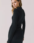 Back view of woman wearing Chaser’s Lara True Black Mini Dress with long sleeves on a white background