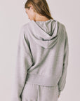 Back view of woman wearing Chaser’s Kiki Heather Grey Zip Up Hoodie on a white background