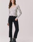 Full body view of woman wearing Chaser’s Tilly Python Print Long Sleeve with black pants and boots on a plain background