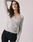 Front view of woman wearing Chaser’s Tilly Python Print Long Sleeve with subtle snakeskin texture on a plain background