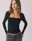 Front view of woman wearing Chaser’s Tilly True Black Long Sleeve with soft ribbed texture on a plain background
