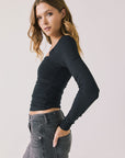 Side view of woman wearing Chaser’s Tilly True Black Long Sleeve on a plain background