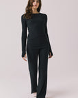 Full body view of woman wearing Chaser’s True Black Mantra Legging with matching Porta True Black Long Sleeve on a plain background