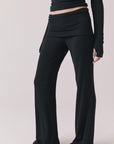 Side view of woman wearing Chaser’s True Black Mantra Legging on a plain background