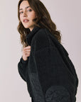 Side view of woman wearing Chaser’s Juno True Black Fleece Jacket on a plain background