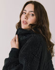 Side view of woman wearing Chaser’s Juno True Black Fleece Jacket on a plain background
