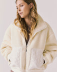 Front view of woman wearing Chaser’s Juno Warm White Fleece Jacket on a plain background