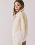Side view of woman wearing Chaser’s Juno Warm White Fleece Jacket on a plain background