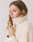 Side view of woman wearing Chaser’s Juno Warm White Fleece Jacket on a plain background
