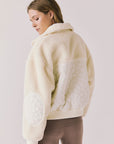 Back view of woman wearing Chaser’s Juno Warm White Fleece Jacket on a plain background