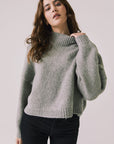 Front view of woman wearing Chaser’s Frankie Heather Grey Pullover Sweater with black pants on a white background