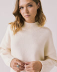 Front view of woman wearing Chaser’s Frankie Warm White Pullover Sweater on a white background