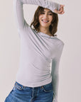 Front view of woman wearing Chaser’s Owen Moonstone Grey Long Sleeve top with a relaxed fit and crew neckline on a light gray background