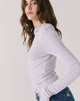 Side view of woman wearing Chaser’s Owen Moonstone Grey Long Sleeve top showing soft drape and lightweight texture on a light gray background