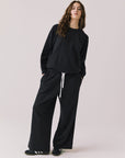 Full body view of woman wearing Chaser’s Cello True Black Pullover with matching Hazel Joggers on a white background