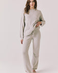 Full body view of woman wearing Chaser’s Miller Heather Grey Pullover Sweater with matching Monica Heather Grey Joggers on a white background