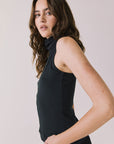 Side view of woman wearing Chaser’s Hailee Black Tank on a white background