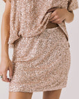 Front view of woman wearing Chaser’s Jayde Bronze Brown Mini Skirt with matching Davis Bronze Brown Tee on a light gray background