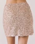 Back view of woman wearing Chaser’s Jayde Bronze Brown Mini Skirt on a light gray background