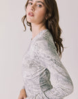 Side view of woman wearing Chaser’s light Opal Python Print Maxi Dress with with long sleeves and a subtle snakeskin pattern against a white background
