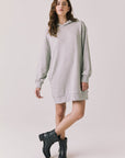 Woman wearing Chaser's Aster Heather Grey Hoodie Dress with black boots on a plain background