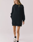 Woman wearing Chaser Aster True Black Hoodie Dress with decorative elements on shoulders on a plain background