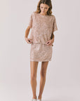 Full body view of woman wearing Chaser’s Davis Bronze Brown Tee and matching Jayde Bronze Brown Mini Skirt on a light gray background