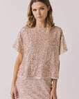 Front view of woman wearing Chaser’s Davis Bronze Brown Tee and matching Jayde Bronze Brown Mini Skirt on a light gray background