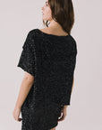 Back view of woman wearing Chaser’s Jayde True Black Mini Skirt with matching Davis True Black Tee on a light gray background