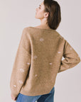 Back view of woman wearing Chaser’s Love Me Long Sleeve Beige Sweater on a plain background