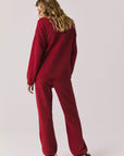 Full body back view of woman wearing Chaser’s Monica Purple-Red Fig Joggers with matching Miller Purple-Red Fig Pullover Sweater on a white background