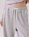 Front view of woman wearing Chaser’s Brandy Light Heather Grey Joggers on a white background