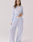 Full body view of woman wearing Chaser’s Brandy Skyway Blue Joggers with matching Spritz Long Sleeve on a white background
