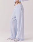 Side view of woman wearing Chaser’s Brandy Skyway Blue Joggers on a white background