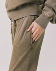 Side view of woman wearing Chaser’s Ginger Brown Manhattan Joggers on a white background