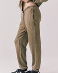 Side view of woman wearing Chaser’s Ginger Brown Manhattan Joggers on a white background