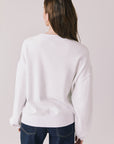 Back view of woman wearing Chaser’s white Vacation Long Sleeve on a light background