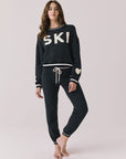 Full body view of woman wearing Chaser’s Ski True Black Long Sleeve Pullover with matching Heart Joggers on a white background