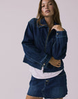 Full body view of the Chaser Sutton Indigo Wash Jacket worn open and styled with the matching Sloane Indigo Wash Mini Skirt