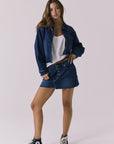 Full body front view of the Chaser Sutton Indigo Wash Jacket styled with the matching Sloane Indigo Wash Mini Skirt