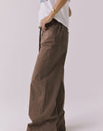 Side view of a woman wearing Chaser's Layover Cognac Wash Jogger against a plain background