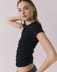 Side view of the Chaser Louis Black Tee showing the flattering ruched design and slim profile