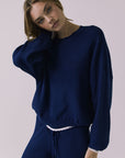 Three-quarter view of the Chaser Rhode Worn Blue Pullover showing the drape and wide sleeve shape