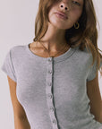 Closeup view of a woman wearing Chaser's heather gray button-up Anchor Tee against a plain background