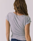 Back view of a woman wearing Chaser's heather gray button-up Anchor Tee against a plain background