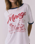 Close up of a woman wearing Chaser's white Desert Mirage Motor Club Tee with red text and graphics on a plain background
