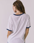 BAck view of a woman wearing Chaser's white Desert Mirage Motor Club Tee on a plain background