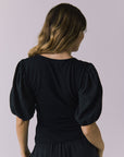 Chaser Abbie Black Blouse in a back close up capturing sleeve volume and soft drape